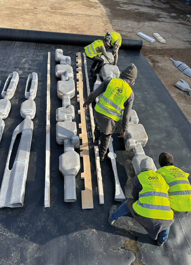 Équipe d'artisans assemblant des éléments de garde-corps métalliques sculptés sur chantier, fabrication sur mesure par l'atelier de métallerie d'art au Maroc