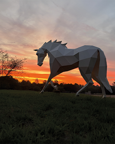 Sculpture cheval style origami installée dans un espace extérieur paysager au Maroc