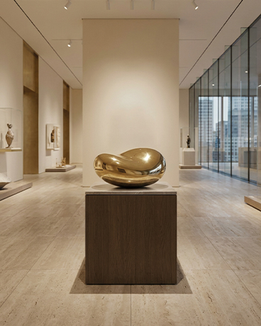 Sculpture organique dorée exposée sur socle dans un musée contemporain au Maroc
