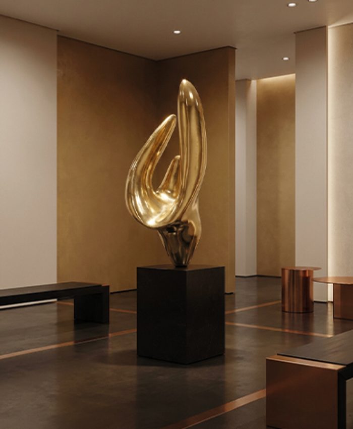 Sculpture dorée contemporaine posée sur un socle noir dans une galerie d’art haut de gamme au Maroc