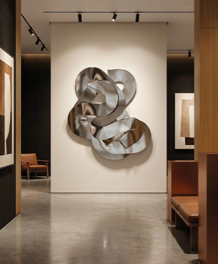 Sculpture murale métallique argentée installée dans une galerie d’art contemporaine au Maroc