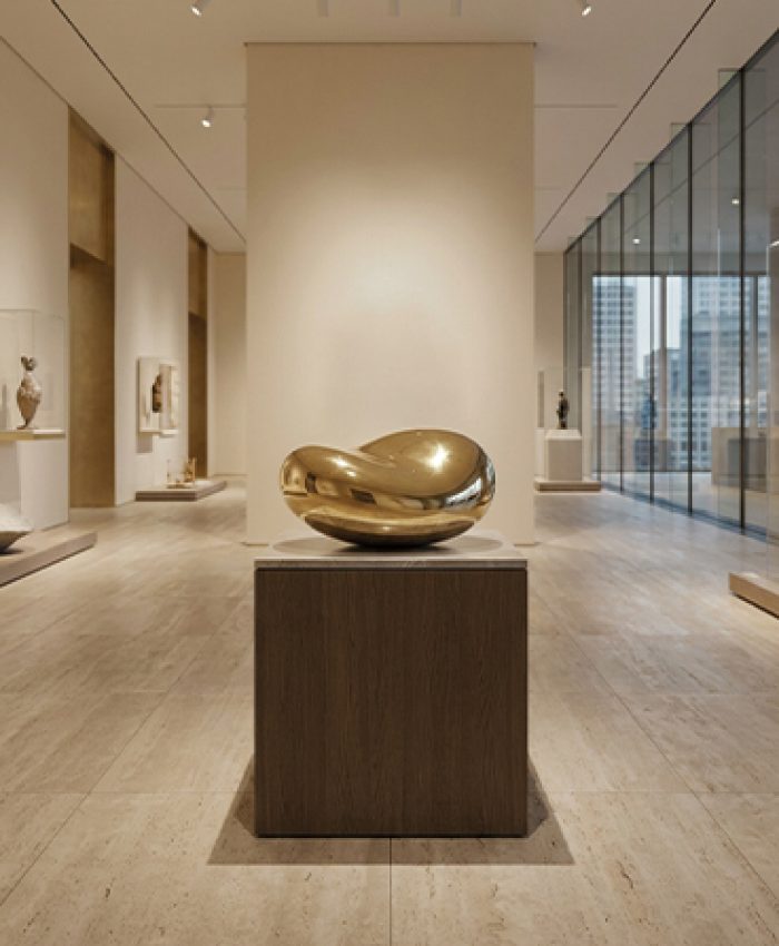Sculpture organique dorée exposée sur socle dans un musée contemporain au Maroc